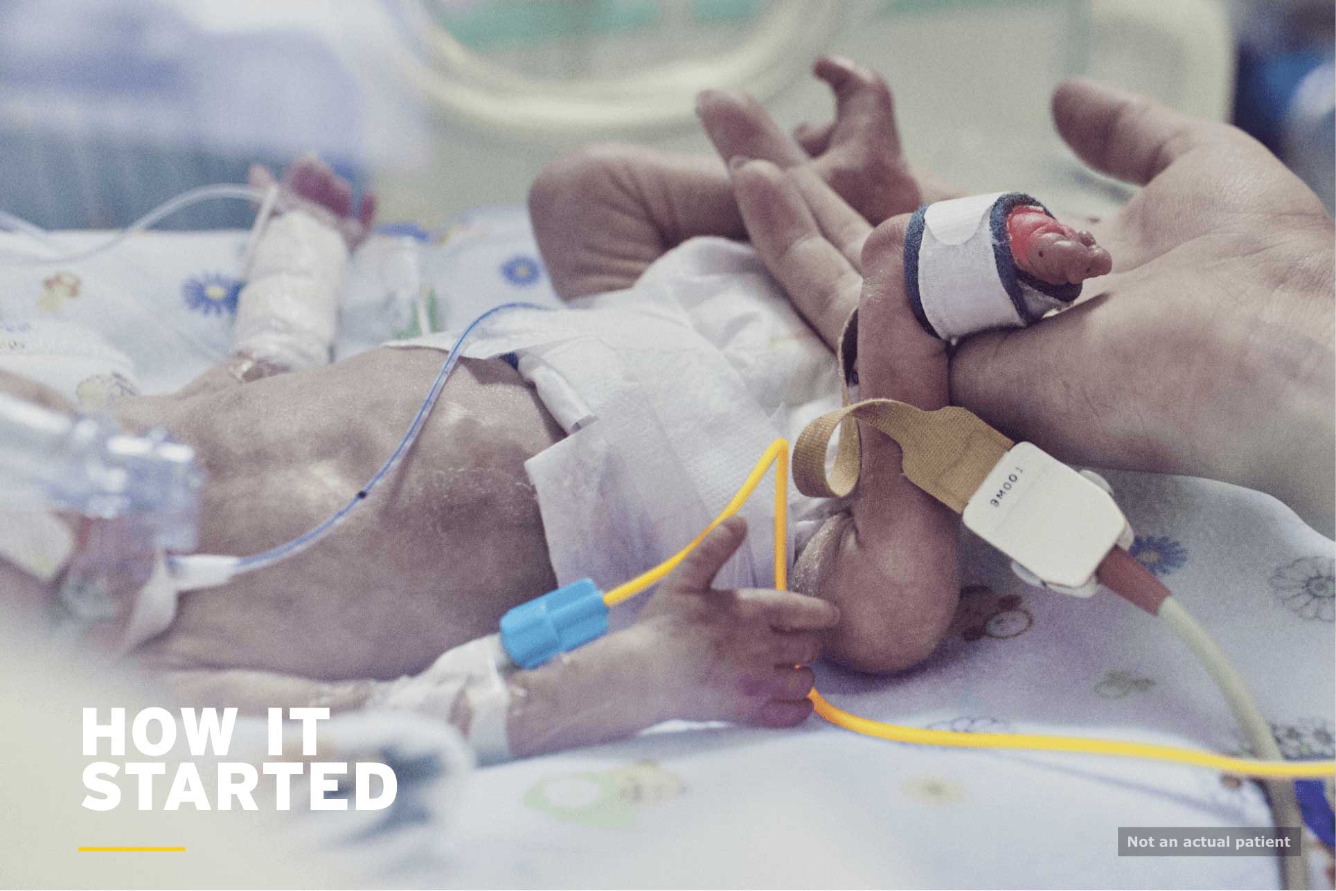 Neonates: baby in incubator with adult hand holding its tiny foot